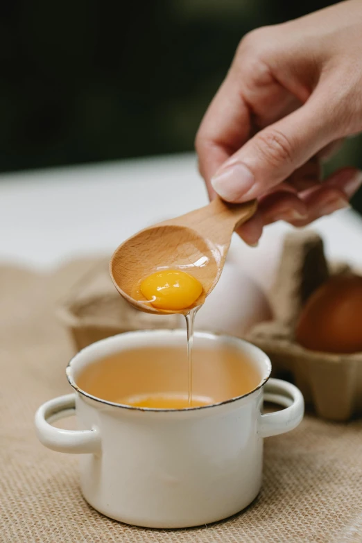 a person dipping an egg into a bowl of soup, unsplash, renaissance, raw egg yolks, made of glazed, spoon, paul barson