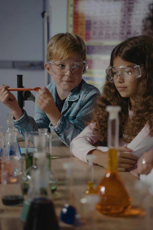 a group of children sitting at a table in a lab, trending on pexels, flasks, inspect in inventory image, thumbnail, cinematic image