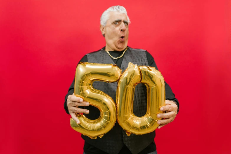 a man holding a golden number 50 balloon, an album cover, by Matt Cavotta, unsplash, pop art, a silver haired mad, danny de vito, plain background, papa john eating 50 pizzas a day