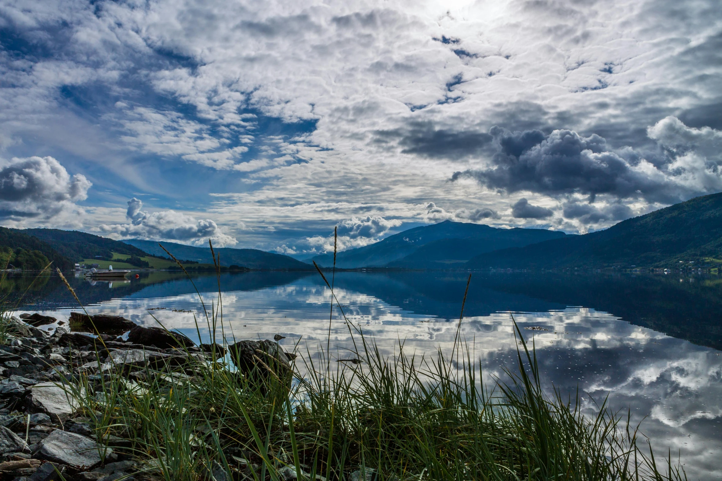 a lake surrounded by grass and rocks under a cloudy sky, by Jan Rustem, pexels contest winner, british columbia, avatar image