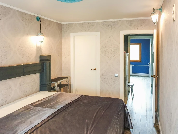 a bed sitting in a bedroom next to a doorway, by Julia Pishtar, unsplash, art nouveau, silver and blue color schemes, located in hajibektash complex, wide high angle view, listing image