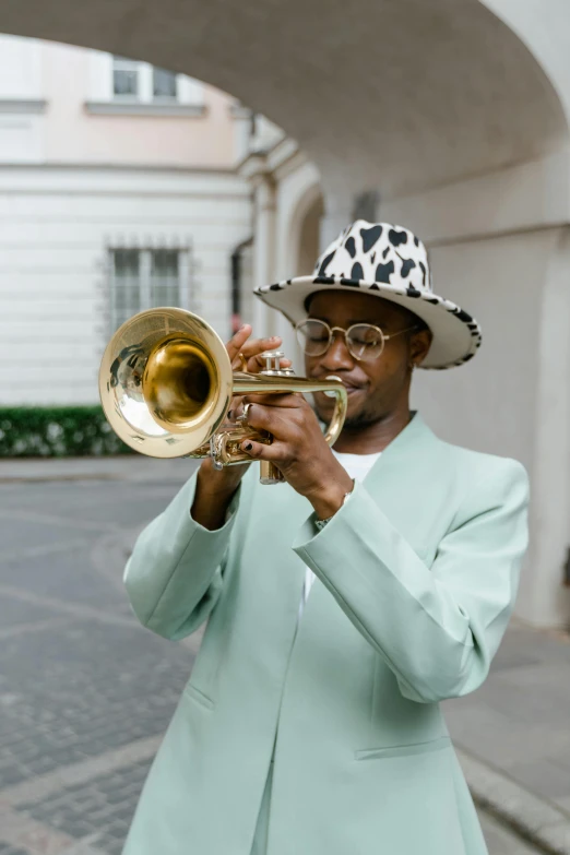 a man in a hat playing a trumpet, pexels contest winner, harlem renaissance, green suit and bowtie, goat horns, instagram post, gold glasses