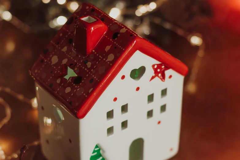 a toy house sitting on top of a table, trending on pexels, red and white lighting, emma bridgewater and paperchase, close face view, ornamented