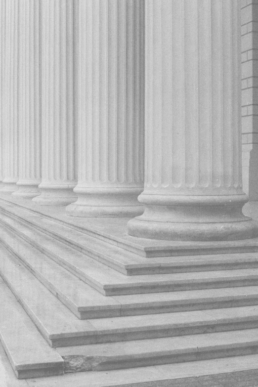 a black and white photo of a row of columns, an ambient occlusion render, flickr, neoclassicism, us court, soft colors mono chromatic, stone steps, finely textured