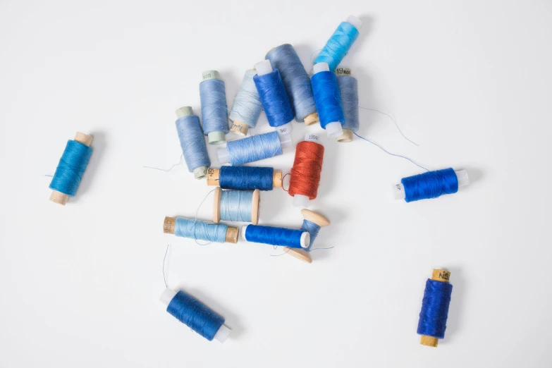 a bunch of spools of thread on a white surface, unsplash, arte povera, wearing blue, ignant, 9 9 designs, thumbnail