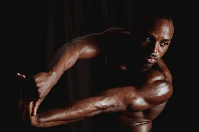 a man flexing his muscles against a black background, pexels contest winner, hyperrealism, deep black skin, gilleard james, smooth contours, portrait photo of a backdrop