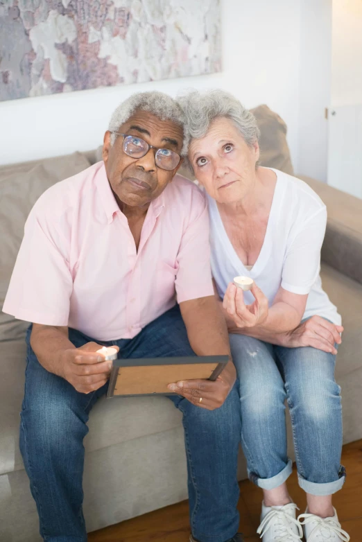 a man and a woman sitting on a couch, the look of an elderly person, sad prisoner holding ipad, lgbtq, photograph