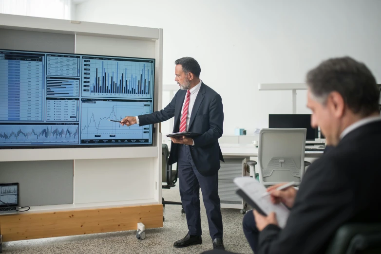 a man giving a presentation to a group of people, a computer rendering, by John Murdoch, unsplash, led displays, traders, on a advanced lab, lachlan bailey