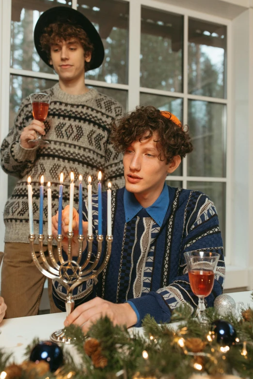 a group of people sitting around a table with a menorah