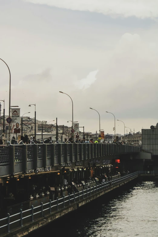 a large long train on a steel track, a picture, unsplash, happening, all buildings on bridge, istanbul, gray sky, 2 5 6 x 2 5 6