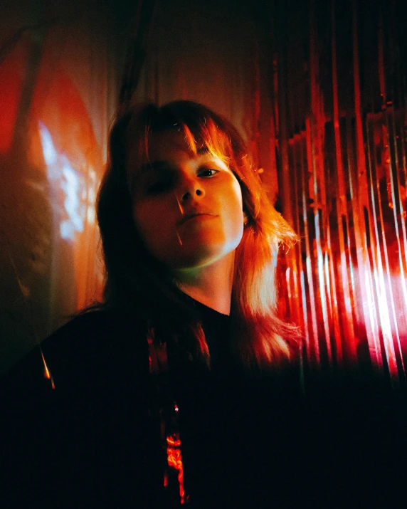 a woman standing in front of a red curtain, inspired by Elsa Bleda, holography, with bangs, lensflares, slightly smiling, trending photo