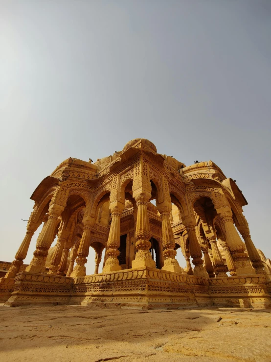 a large stone structure sitting in the middle of a desert, by Rajesh Soni, renaissance, golden colour, in front of the temple, up-close, sandstone