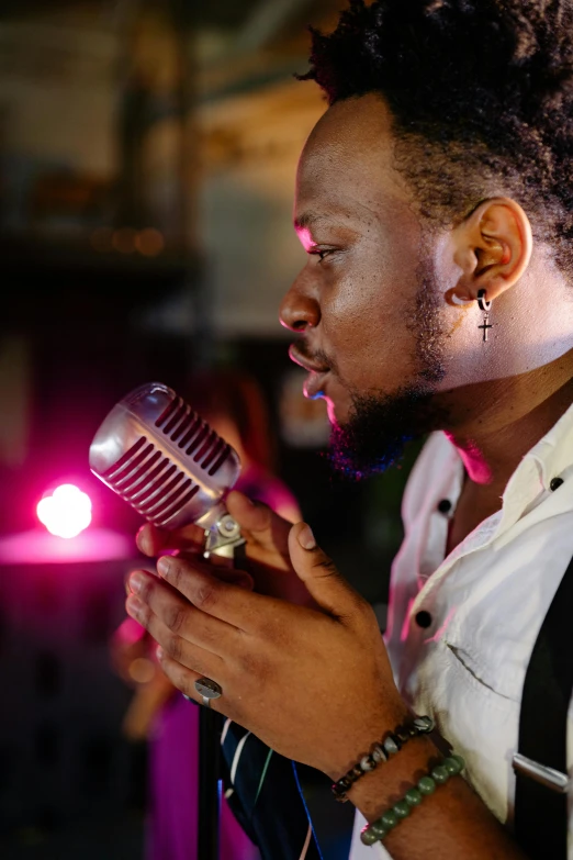 a man with dreadlocks holding a microphone, an album cover, pexels, happening, elegant atmosphere, kendrick lamar, reflecting light in a nightclub, thumbnail