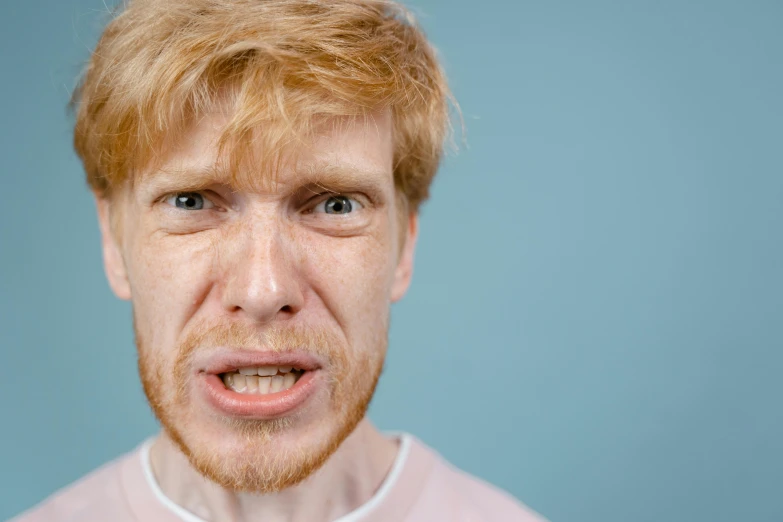 a man with a surprised look on his face, trending on pexels, hyperrealism, ginger hair, with a very large mouth, angry frown, extremely pale