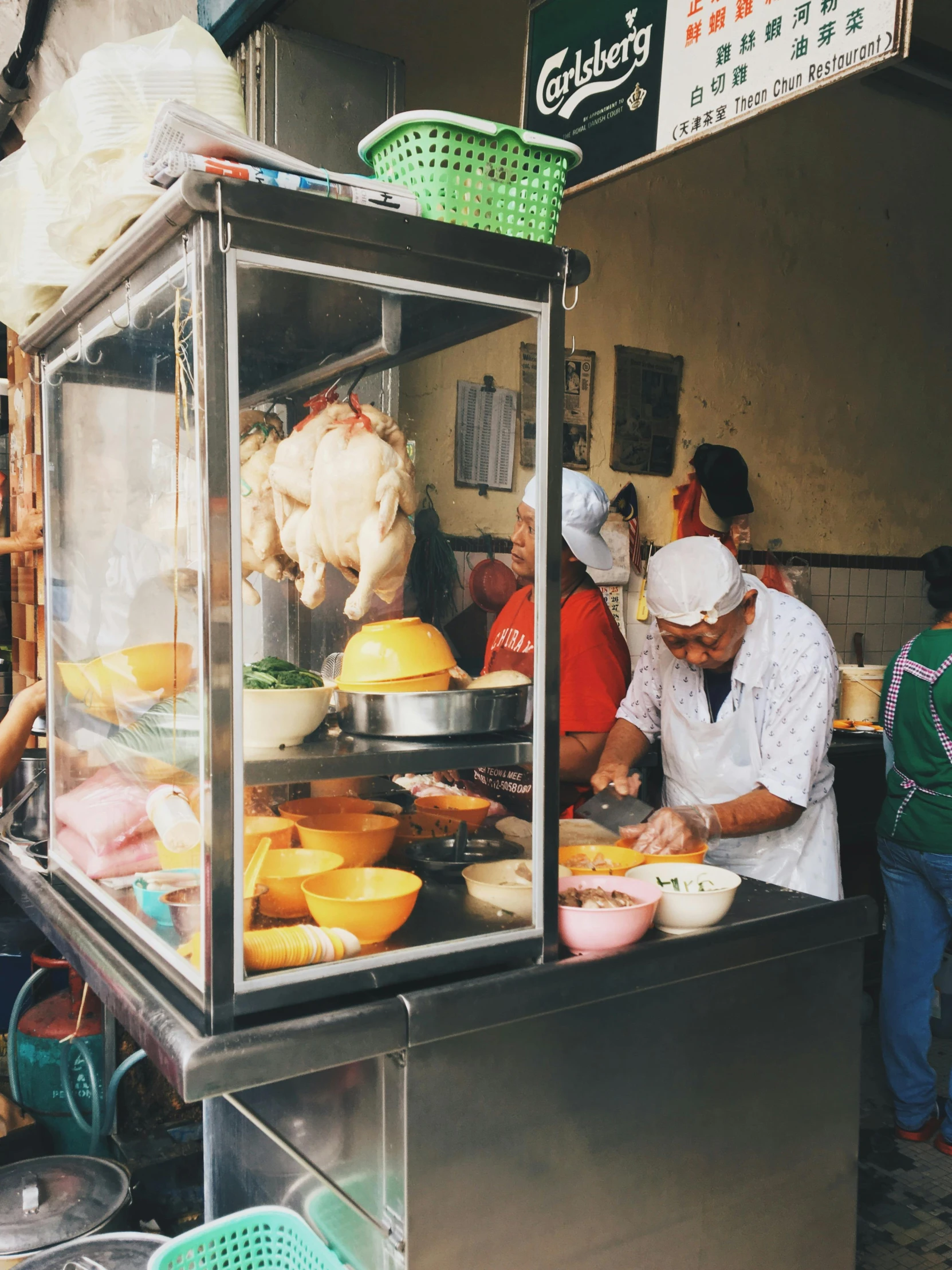 a group of people standing around a food stand, bowl filled with food, chicken, profile image, bao phan