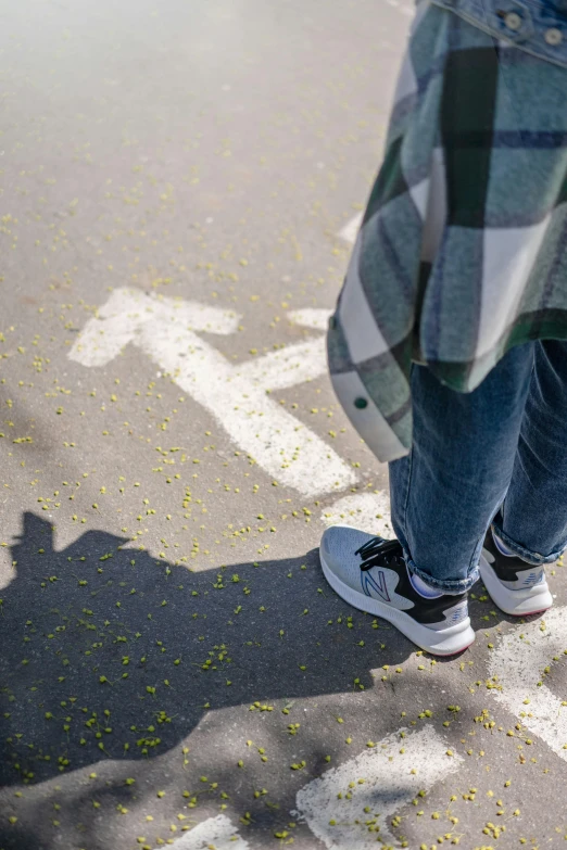 a person standing in the middle of a street, acid-green sneakers, with two arrows, non-binary, soft shadow transition