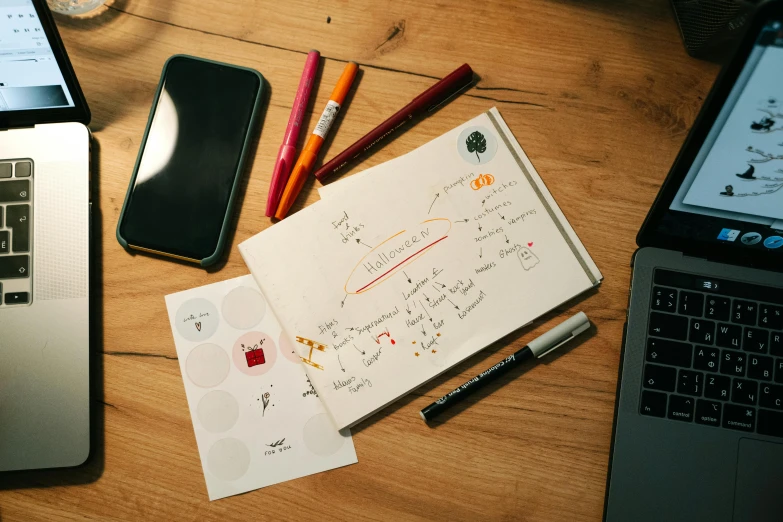 an open laptop computer sitting on top of a wooden table, a drawing, by Daniel Lieske, pexels, with notes, miscellaneous objects, markers, cell journal