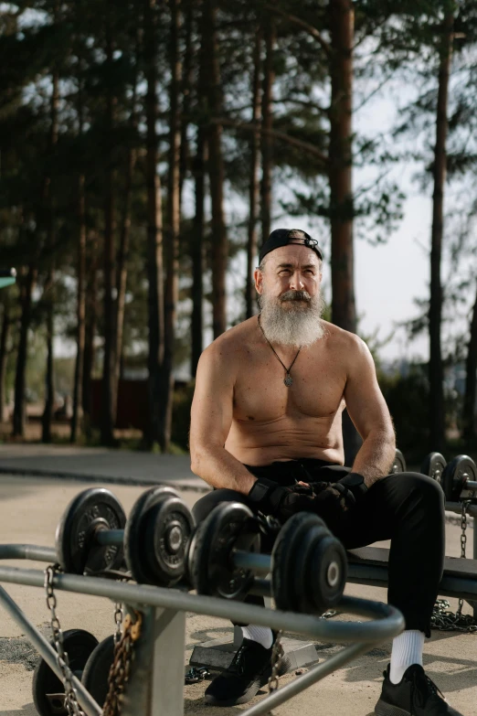 a man with a beard sitting on a bench, carrying two barbells, long white beard, jovana rikalo, photo of a 50-year-old white man