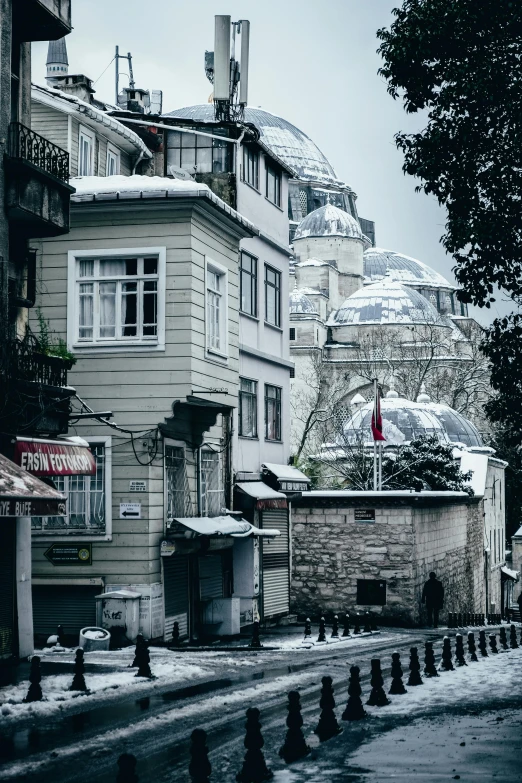 a street filled with lots of snow next to tall buildings, by Niyazi Selimoglu, pexels contest winner, art nouveau, ottoman sultan, dome, in the hillside, grey