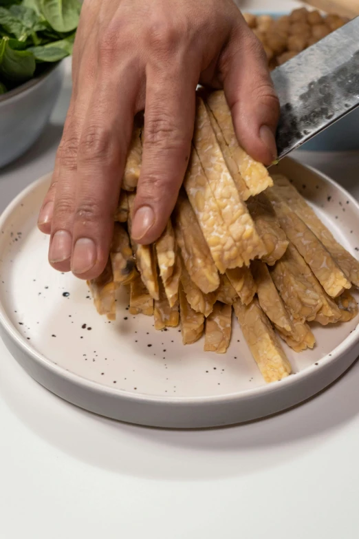 a close up of a person cutting food on a plate, inspired by Pia Fries, colombian, crackles, tall thin, thumbnail