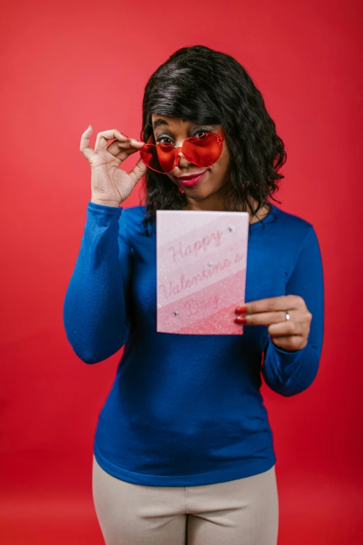 a woman holding a piece of paper in front of her face, red sunglasses, greeting card, pose 4 of 1 6, heart eyes