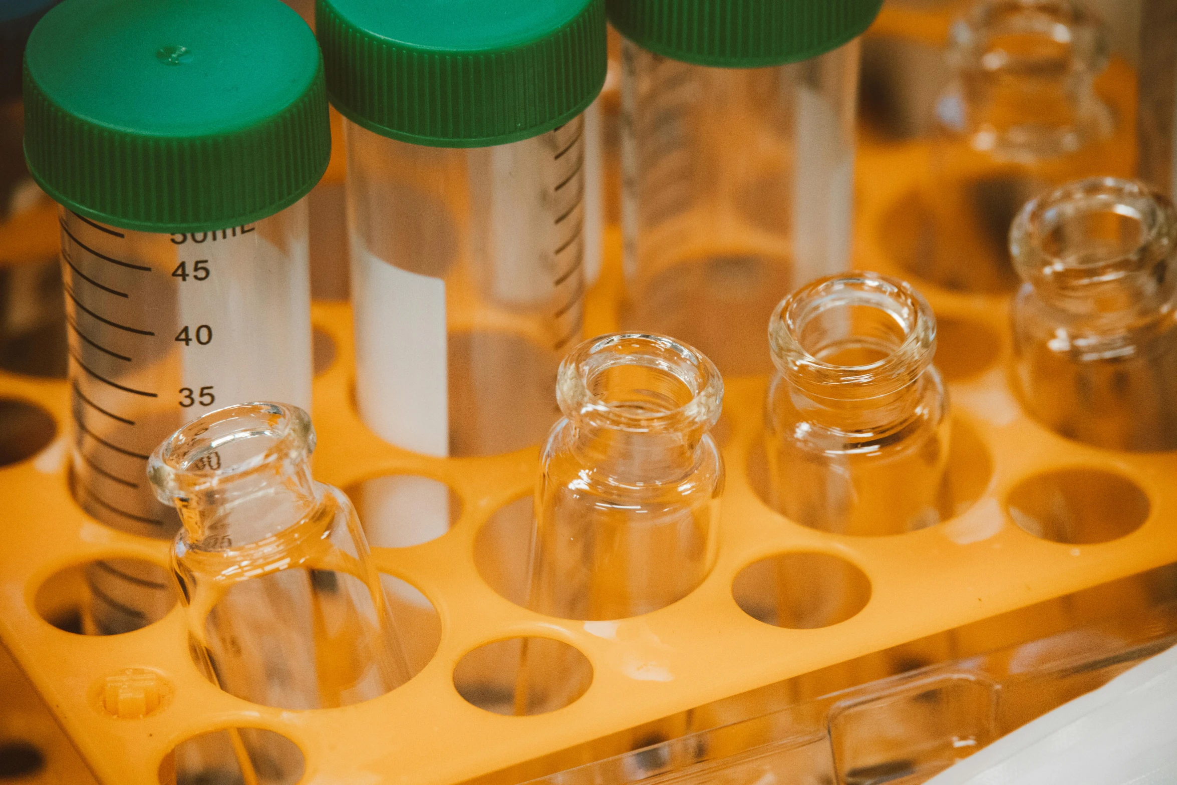 a group of vials sitting on top of a yellow tray, trending on pexels, in a lab, panels, screengrab, biomaterial