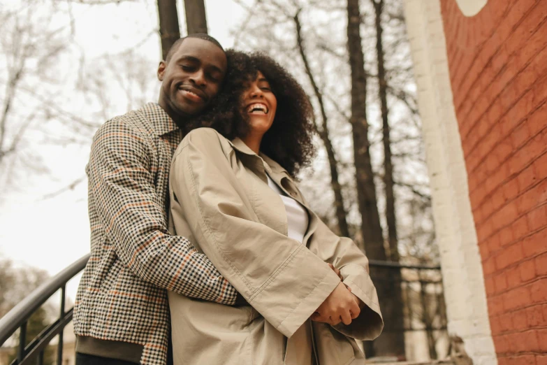 a man and a woman standing next to each other, by Carey Morris, pexels contest winner, happening, happy cozy feelings, brown skinned, hugging, spring season