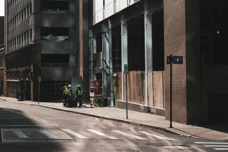 a couple of men standing on the side of a road, by Dan Frazier, pexels contest winner, photorealism, collapsed building, workers, pittsburgh, shady alleys