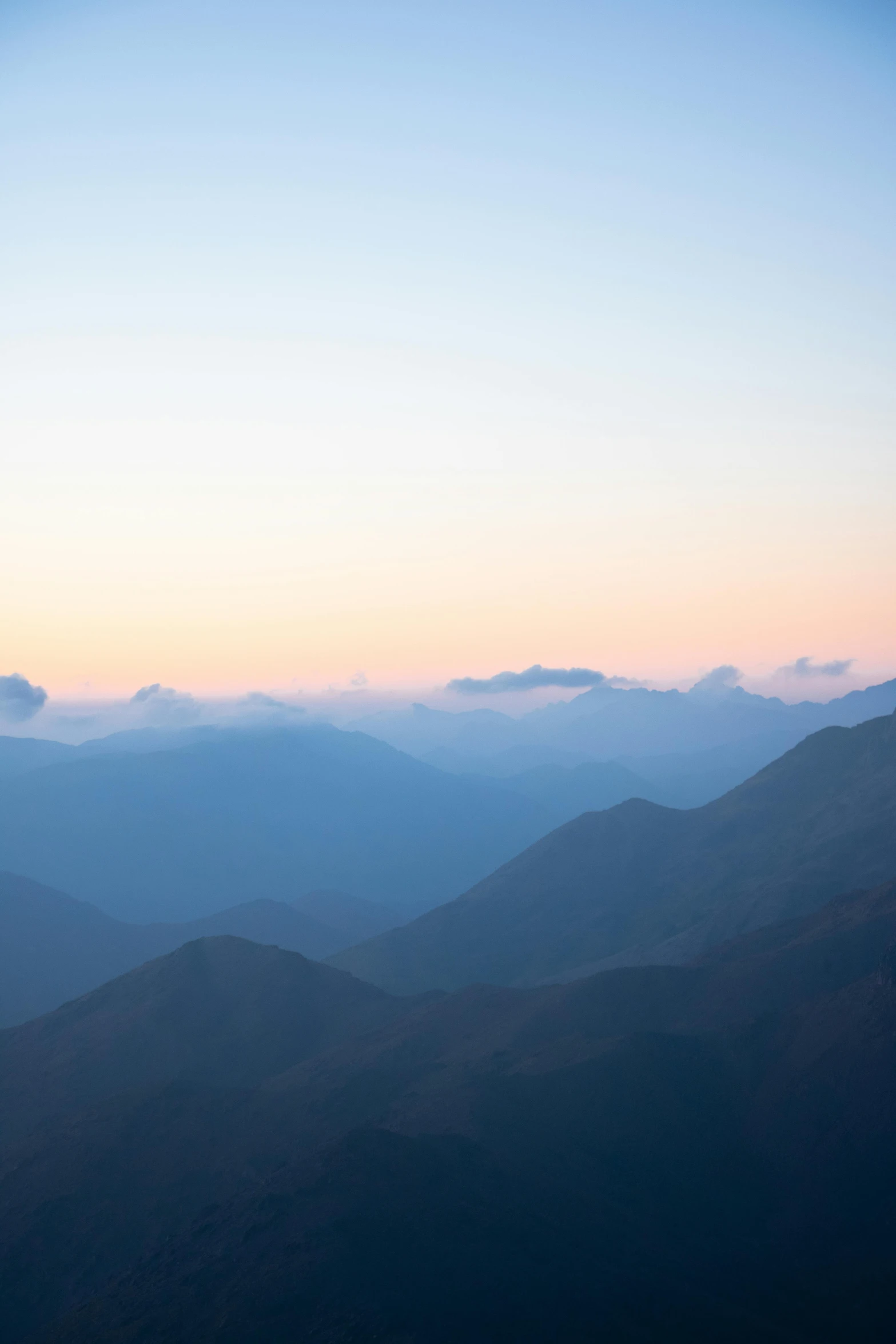 a view of the mountains from the top of a mountain, by Peter Churcher, trending on unsplash, sumatraism, is at dawn and bluish, uttarakhand, warm shades of blue, in a sunset haze