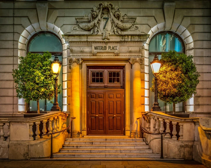 the entrance to a building lit up at night, inspired by Christopher Wren, pexels contest winner, cover shot, warm glow, national geograph, grand library