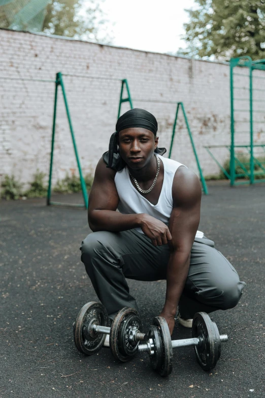 a man squatting on a skateboard in a parking lot, an album cover, pexels contest winner, man is with black skin, lifting weights, androgynous person, portrait photo