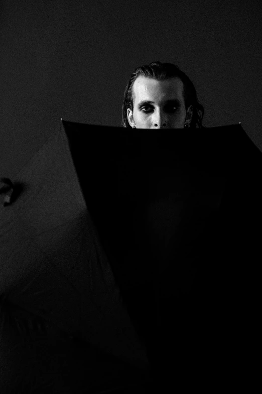 a black and white photo of a man holding an umbrella, a black and white photo, unsplash, bauhaus, portrait of a vampire, square, michael hussar, jamie campbell bower