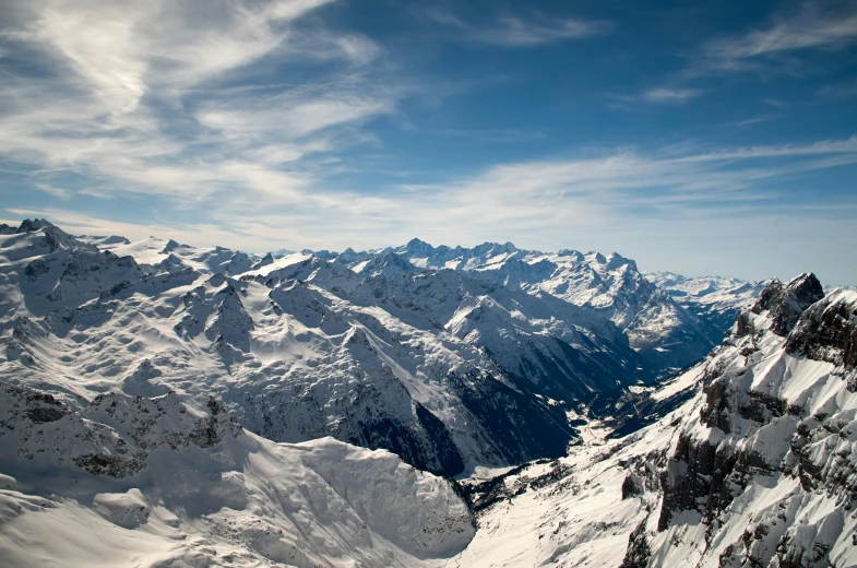 a man standing on top of a snow covered mountain, by Peter Churcher, pexels contest winner, hurufiyya, “ aerial view of a mountain, swiss alps, avatar image, a cozy