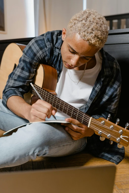 a man sitting on the floor playing a guitar, trending on pexels, writing in journal, headshot, ashteroth, a blond