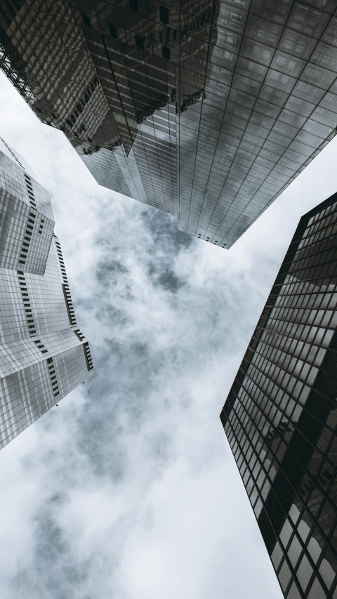 a group of tall buildings in a city, by Adam Rex, pexels contest winner, clouds around, looking downwards, thumbnail, multiple stories