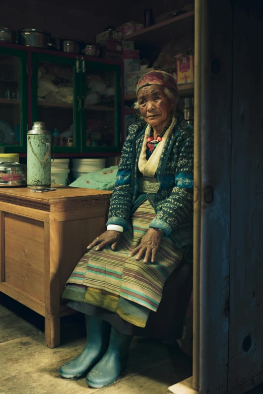 a woman sitting in the doorway of a kitchen, by Jan Tengnagel, pexels contest winner, hyperrealism, sci-fi tibetan fashion, elderly, inuk, slide show