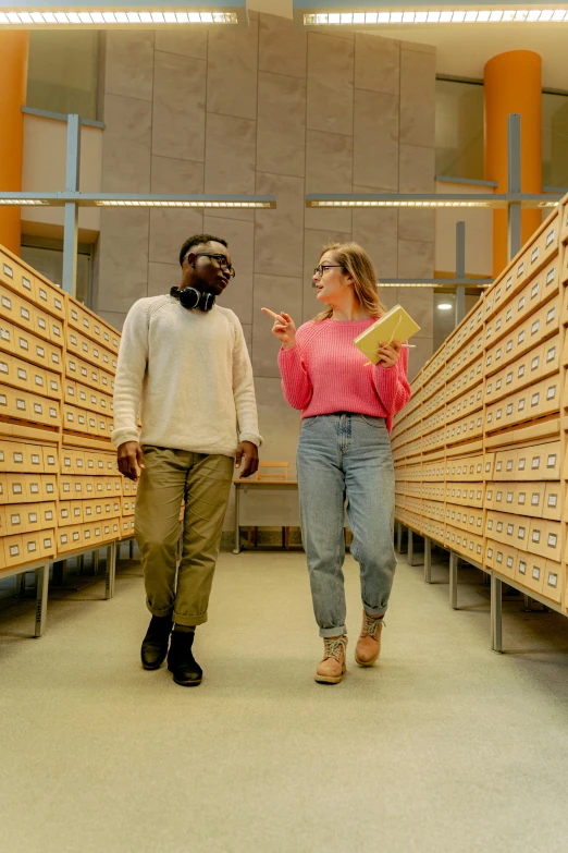 a man and a woman walking through a library, by Eero Järnefelt, pexels contest winner, academic art, colorized, research complex, thomas danthony and malika favre, press shot