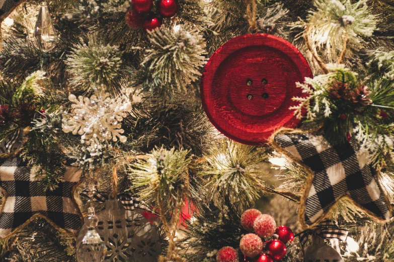 a close up of a christmas tree with ornaments, by Emma Andijewska, pexels, buttons, background image, a cozy, crimson themed