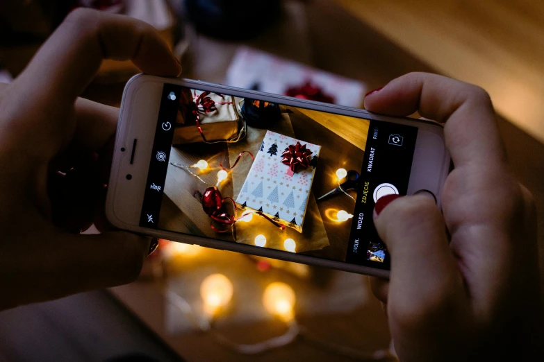 a person taking a picture of a cake on a cell phone, a picture, by Julia Pishtar, pexels contest winner, giving gifts to people, lit from above, holiday, gif