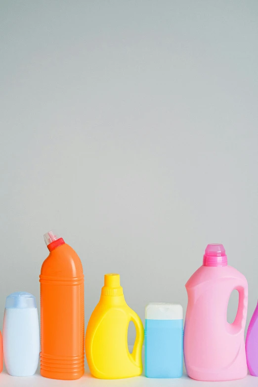 a row of plastic bottles sitting next to each other, on a gray background, thumbnail, spray, profile image