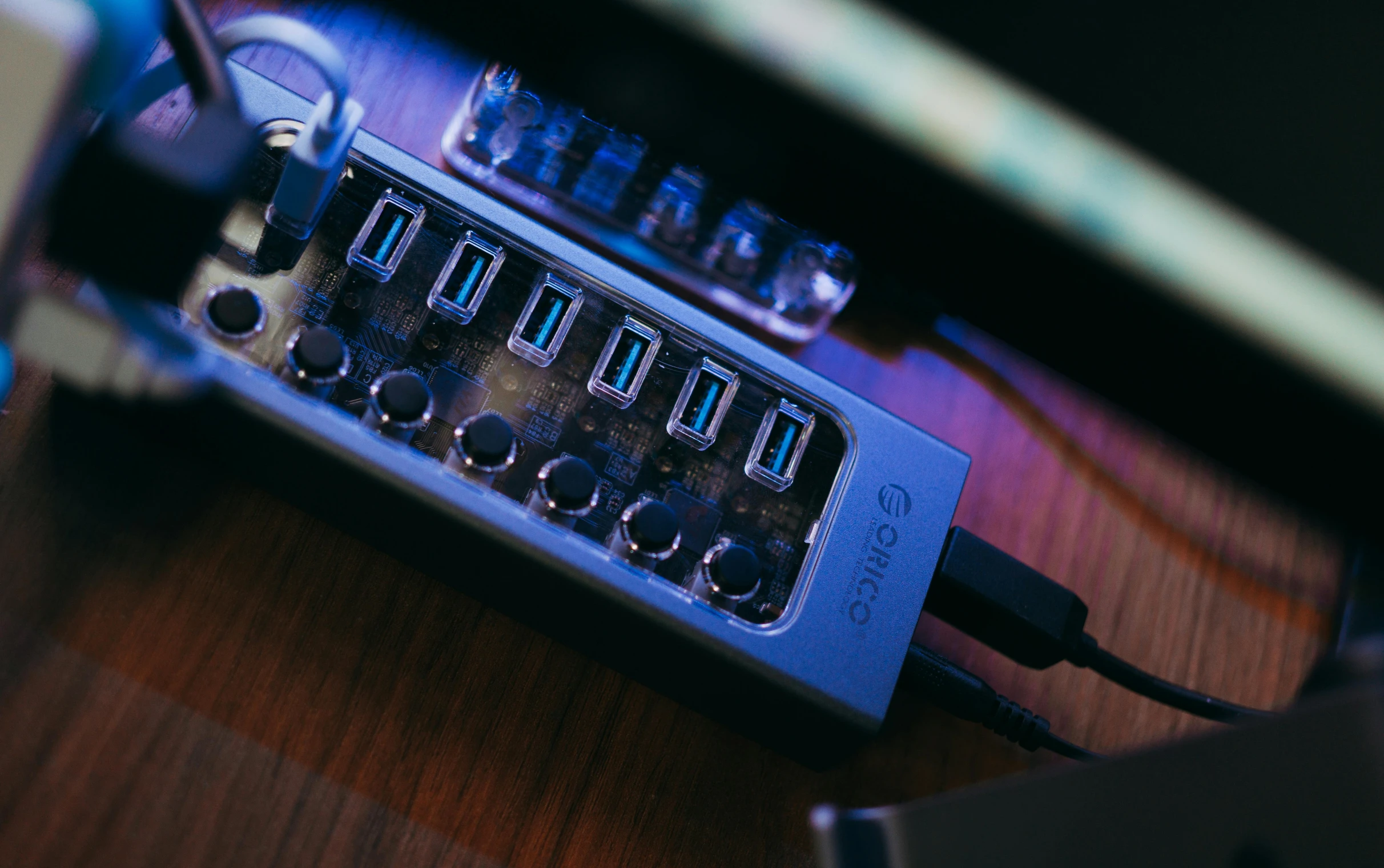 a laptop computer sitting on top of a wooden desk, by Elsa Bleda, pexels, small nixie tubes, blue, usb ports, high angle close up shot