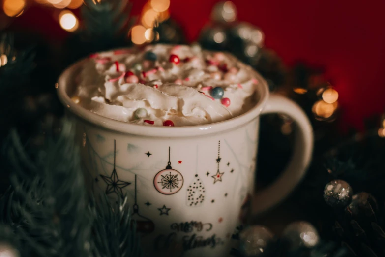 a close up of a cup of hot chocolate, by Emma Andijewska, pexels, christmas night, background image, sprinkles, whipped cream