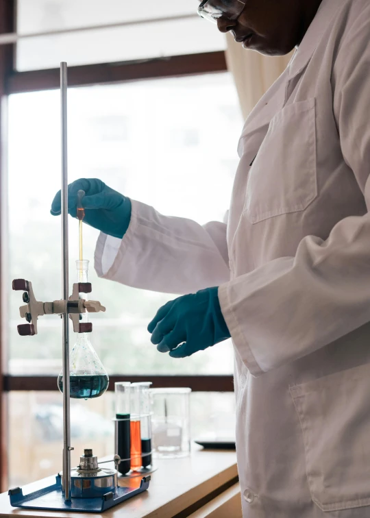 a woman in a lab coat holding a test tube, pexels, wearing a blue robe, instagram picture, brown, panels