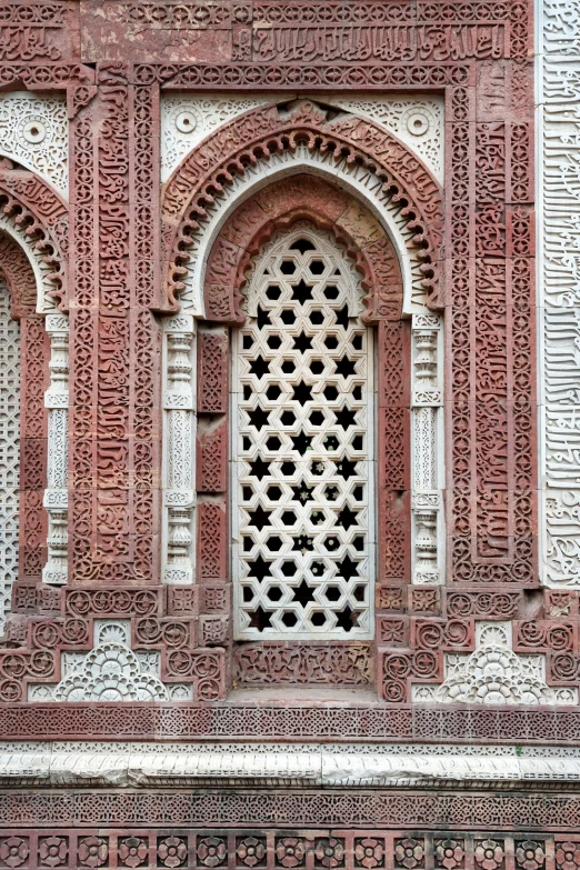 a man sitting on a bench in front of a building, a mosaic, arabesque, crimson and white color scheme, bangladesh, pointed arches, stone relief