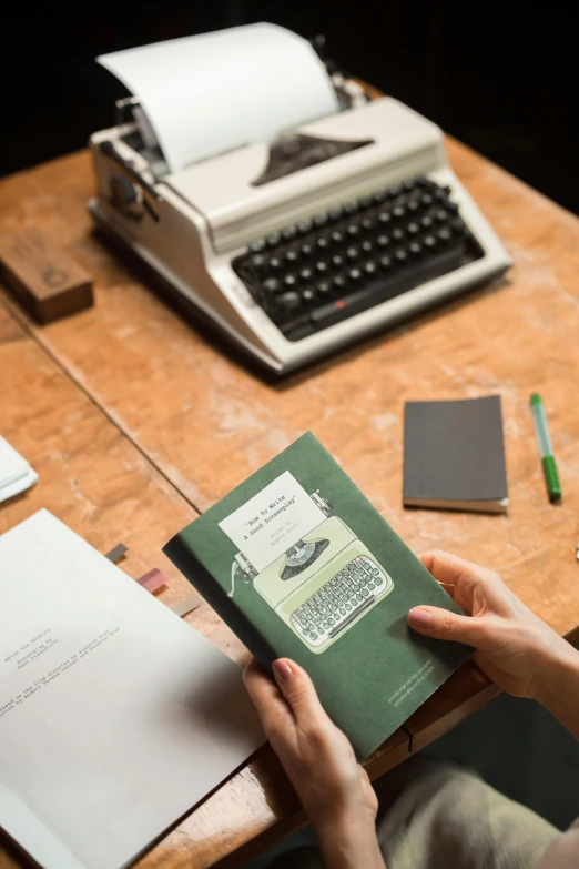 a person sitting at a table with a book and a typewriter, premium quality, thumbnail, overview, multiple stories