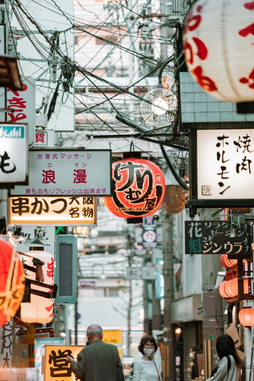 a group of people walking down a street next to tall buildings, inspired by Kanō Naizen, trending on unsplash, ukiyo-e, glowing street signs, food stalls, ethnicity : japanese, old signs