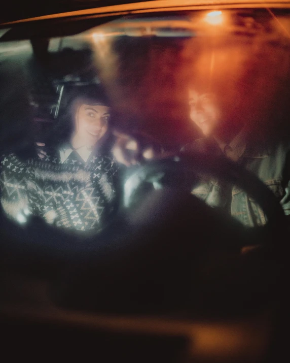 a woman sitting in the driver's seat of a car, a polaroid photo, inspired by Elsa Bleda, happening, seen through a kaleidoscope, lgbtq, low iso, boke