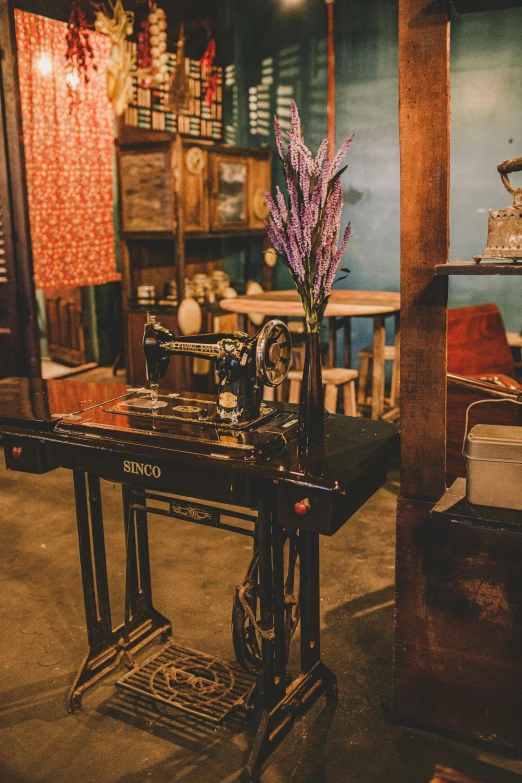 a sewing machine sitting on top of a wooden table, a silk screen, unsplash, inside an old magical shop, bangkok, multiple stories, standing elegantly