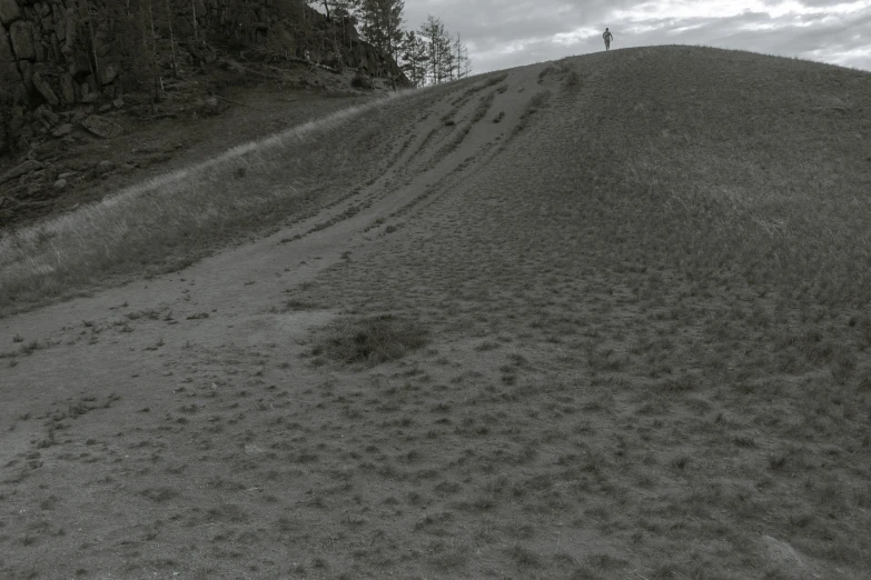 a man riding a snowboard down a snow covered slope, a black and white photo, inspired by Ruth Brandt, land art, moss and mud, standing in sand, point cloud, in a dried out field