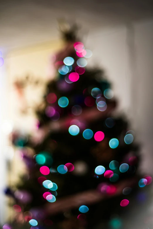 a blurry photo of a christmas tree in a living room, pexels, light and space, colourful close up shot, rain lit, tall, boke